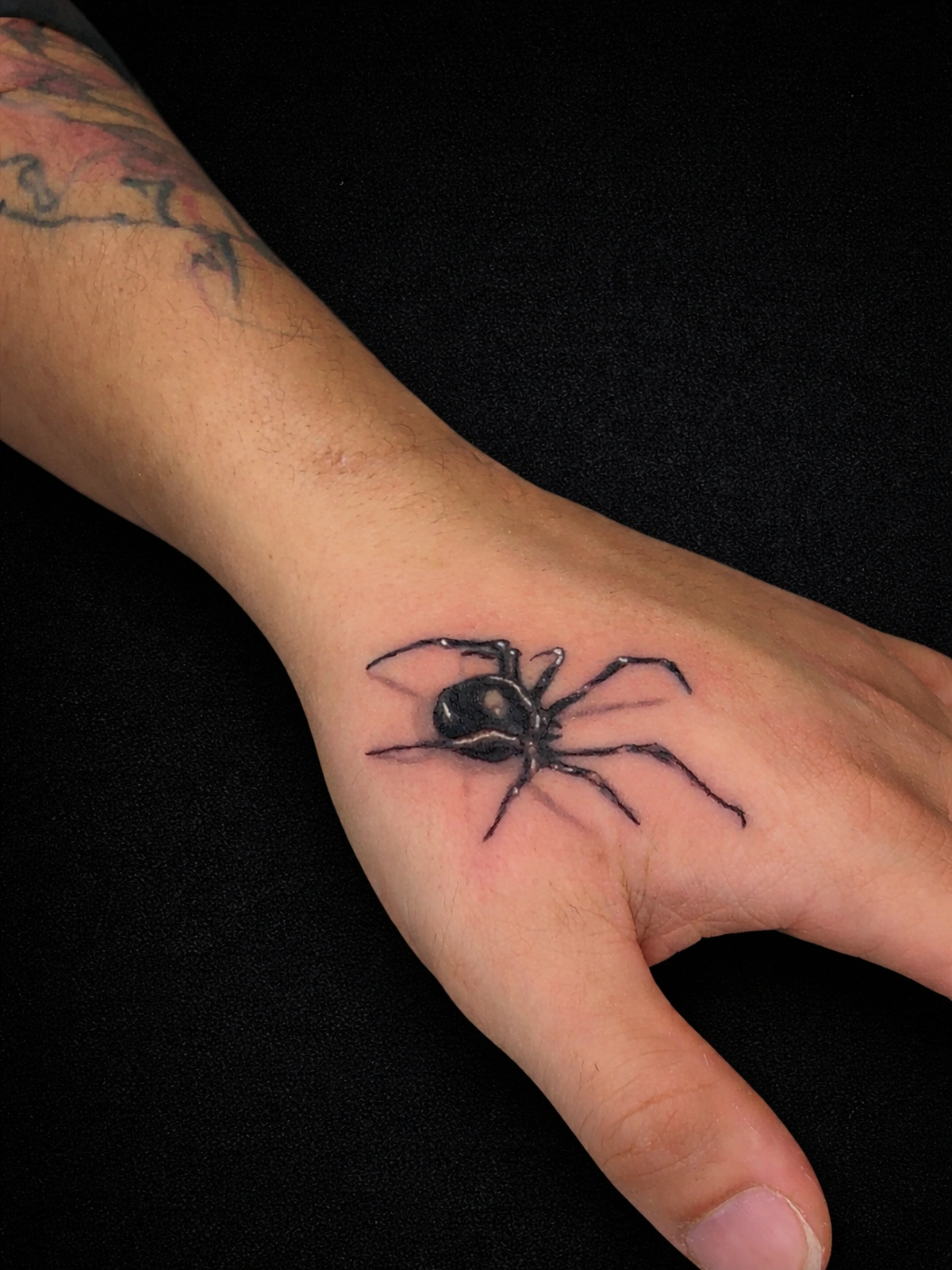 Bold black and grey hand tattoo with strong structure and contrast